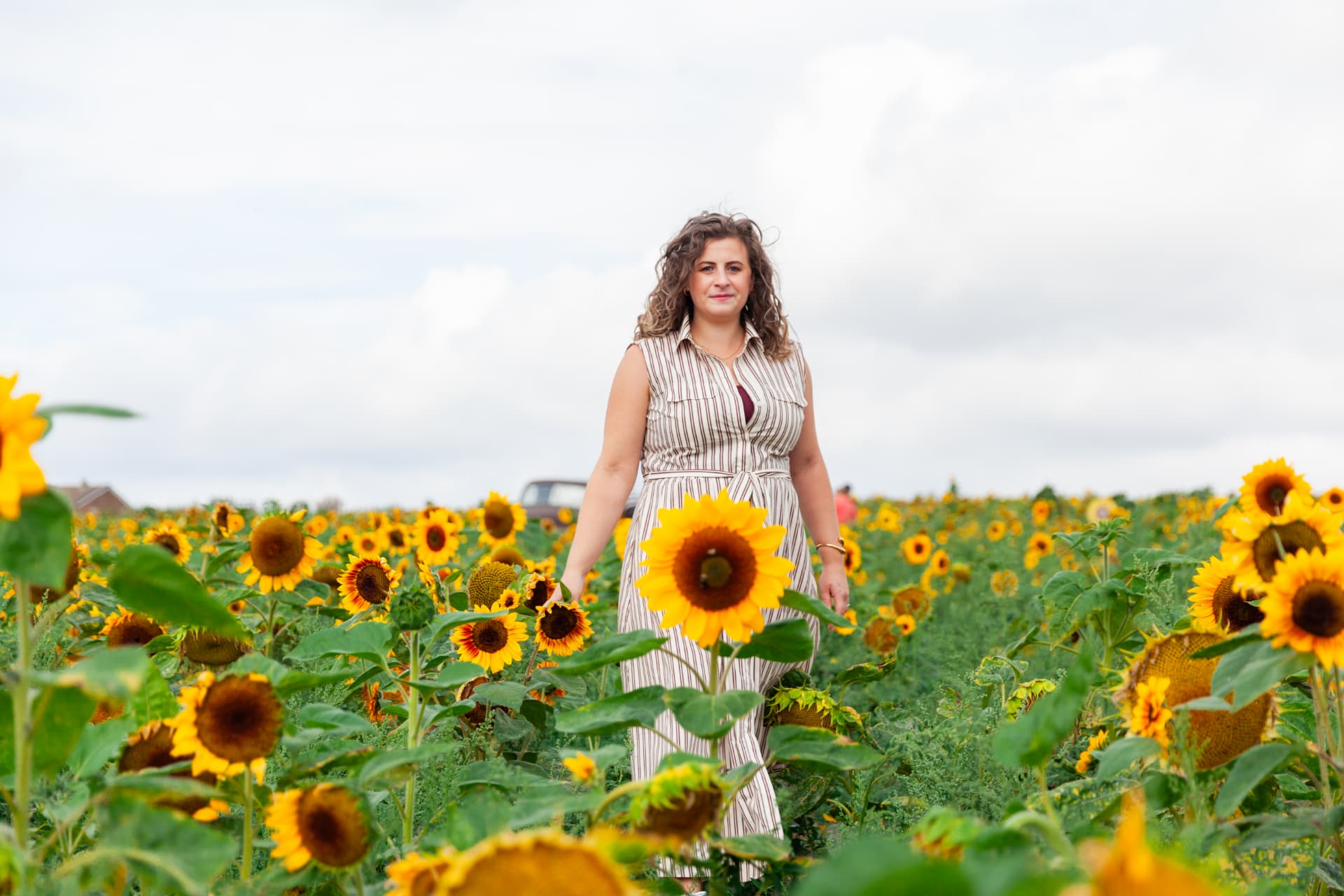 Kate Keir walking through a sunflower field, smiling