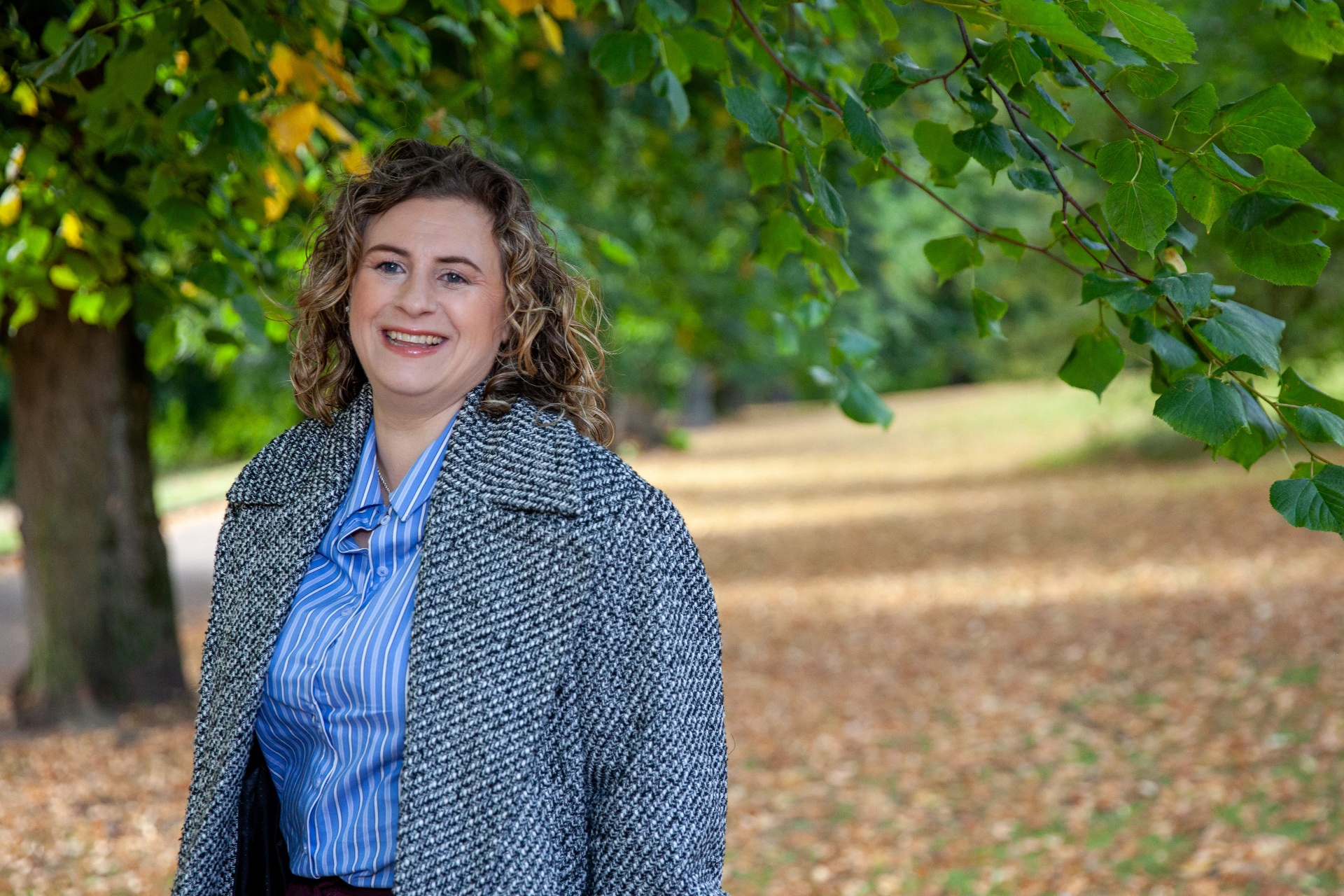 Kate Keir smiling outdoors under a tree.